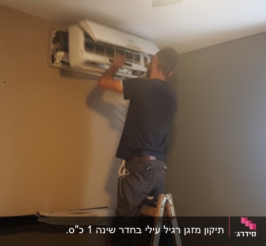 אדם מתקן מזגן על קיר בעזרת סולם